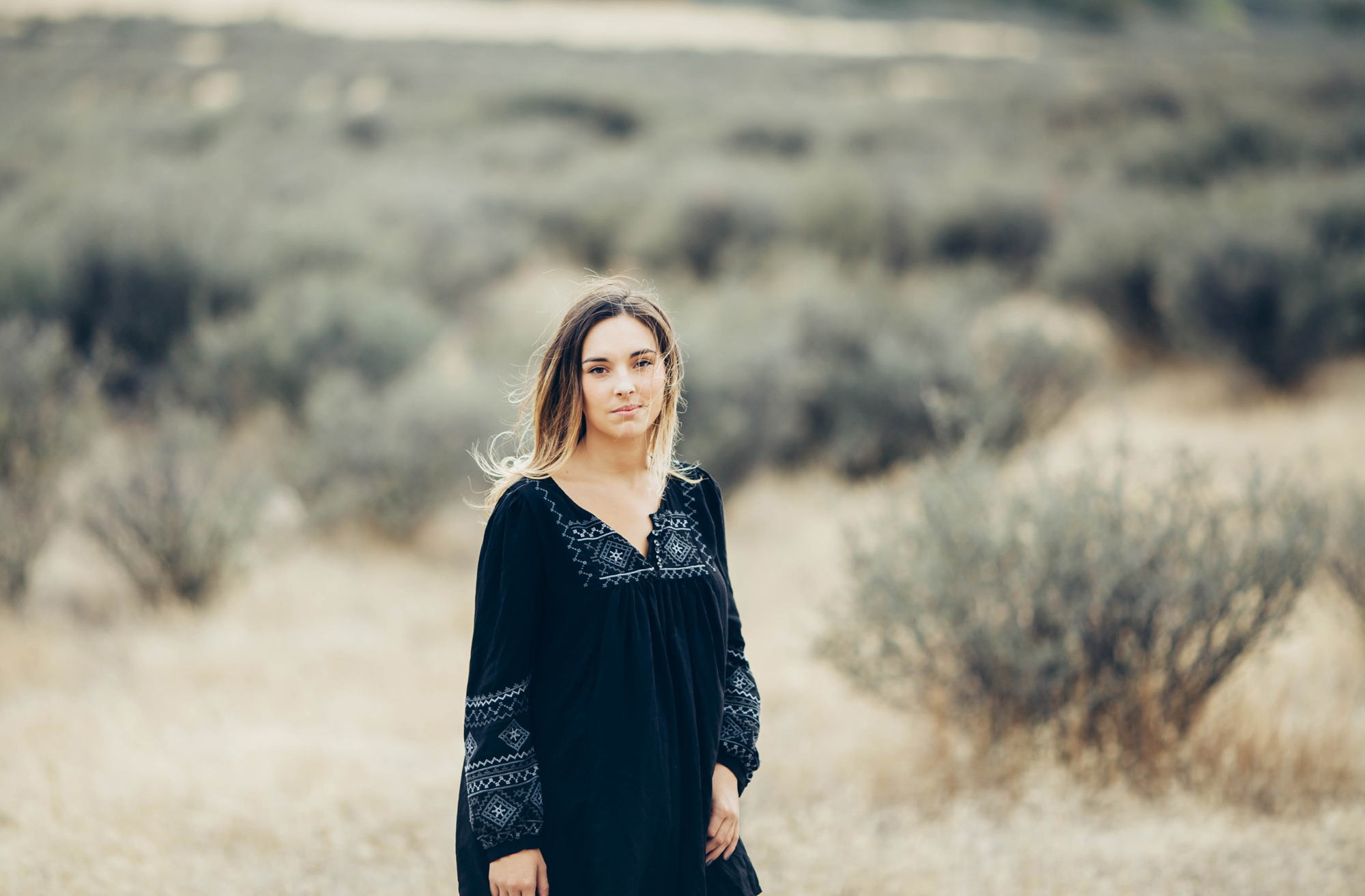 Black dress against windswept brown plains